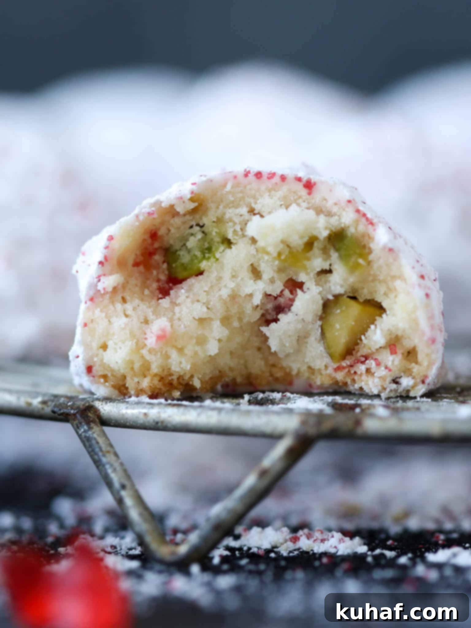 Cherry Pistachio Snowball Cookies Crumb: A close-up showing the tender crumb and flecks of cherry and pistachio in a festive snowball cookie.