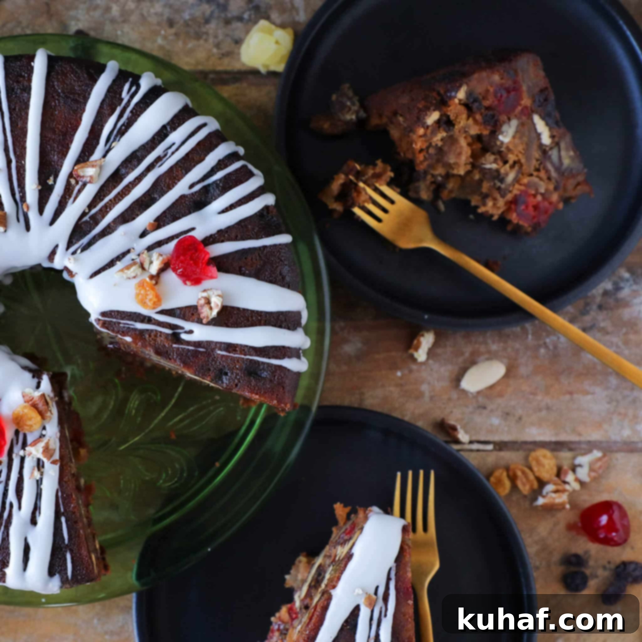 A beautifully presented slice of Christmas fruit cake on a white plate, with a golden fork poised to take a bite.
