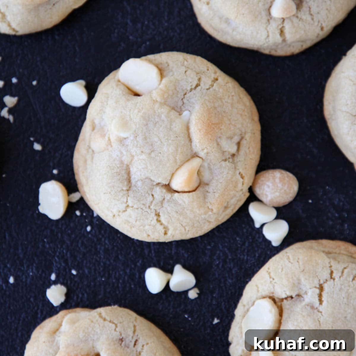 White Chocolate Macadamia Nut Cookies on a dark countertop.