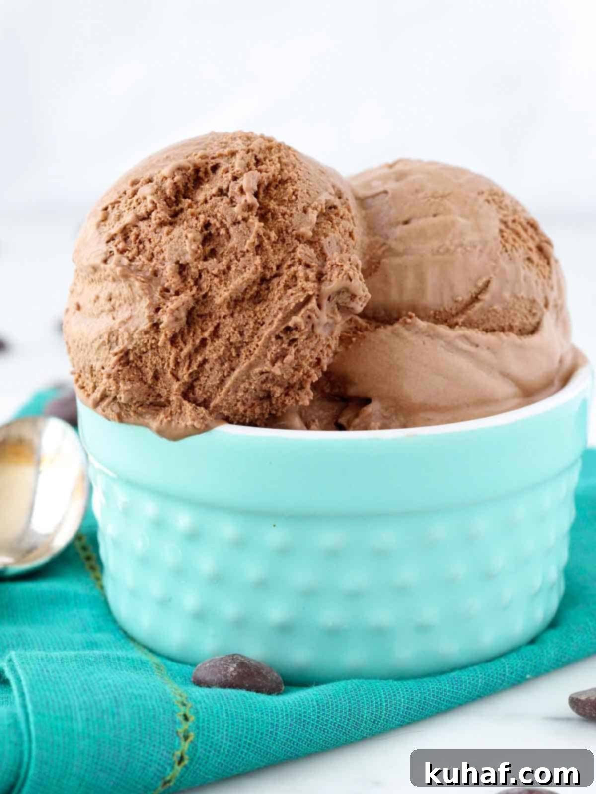 Velvety Homemade Chocolate Ice Cream 3 Three scoops of delectable chocolate ice cream in a vibrant teal bowl, garnished with chocolate shavings.