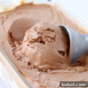 Velvety Homemade Chocolate Ice Cream 5 Perfect scoop of chocolate ice cream being served from a frozen glass dish, showcasing its creamy texture.