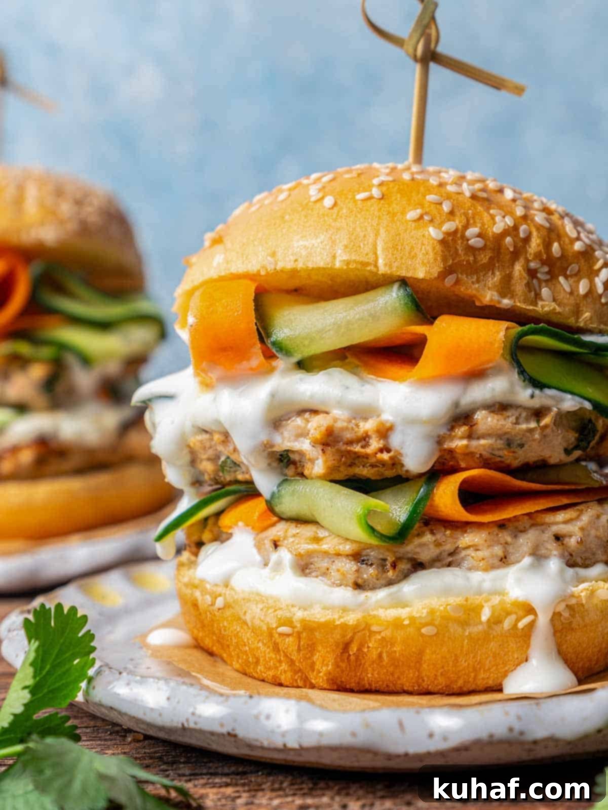 Juicy Chicken Burgers 2 chicken burger stacked with veggies and sauce.