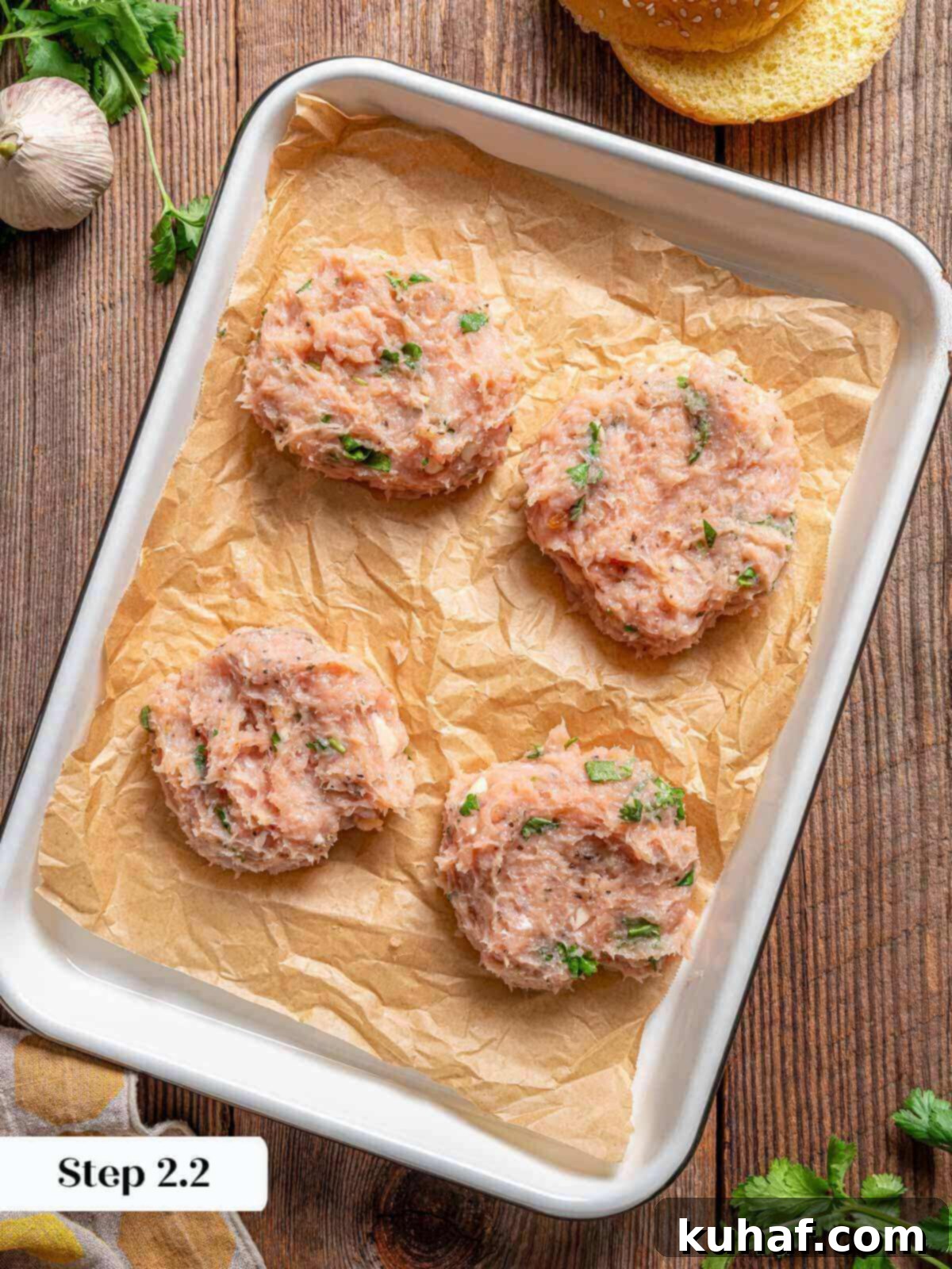 Juicy Chicken Burgers 6 shaped chicken patties on parchment lined baking sheet.