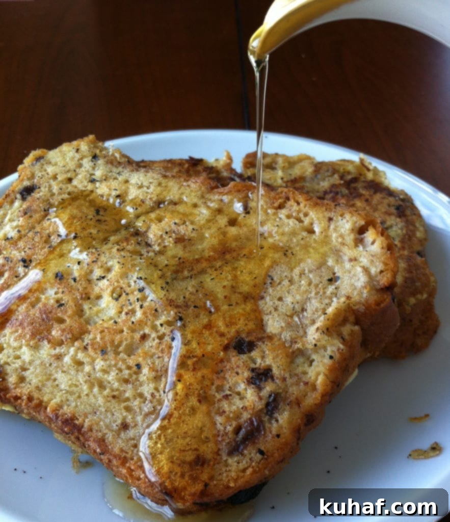 Decadent Cinnamon Raisin French Toast 2 Golden brown Cinnamon Raisin French Toast with warm maple syrup pouring over it, garnished with a sprinkle of powdered sugar