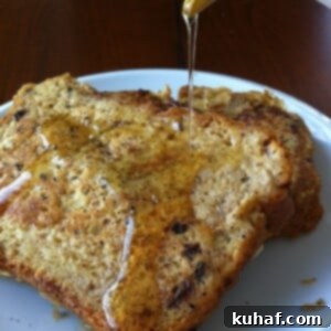 Decadent Cinnamon Raisin French Toast 3 Close-up of golden brown Cinnamon Raisin French Toast with warm maple syrup