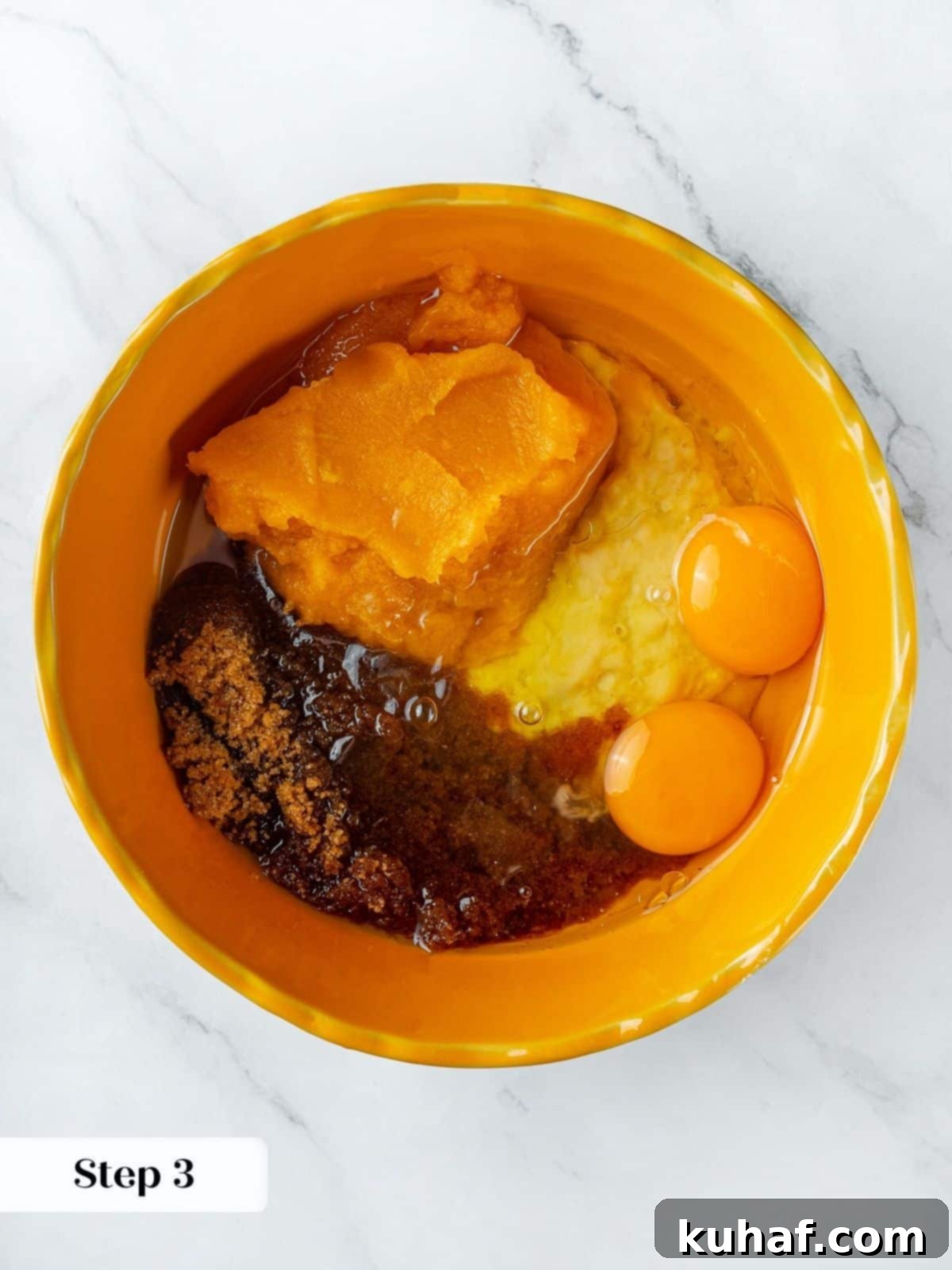 A large mixing bowl containing mashed bananas, pumpkin puree, eggs, brown sugar, and vanilla extract, all ready to be thoroughly combined into a smooth, homogenous wet mixture for pumpkin banana bread.