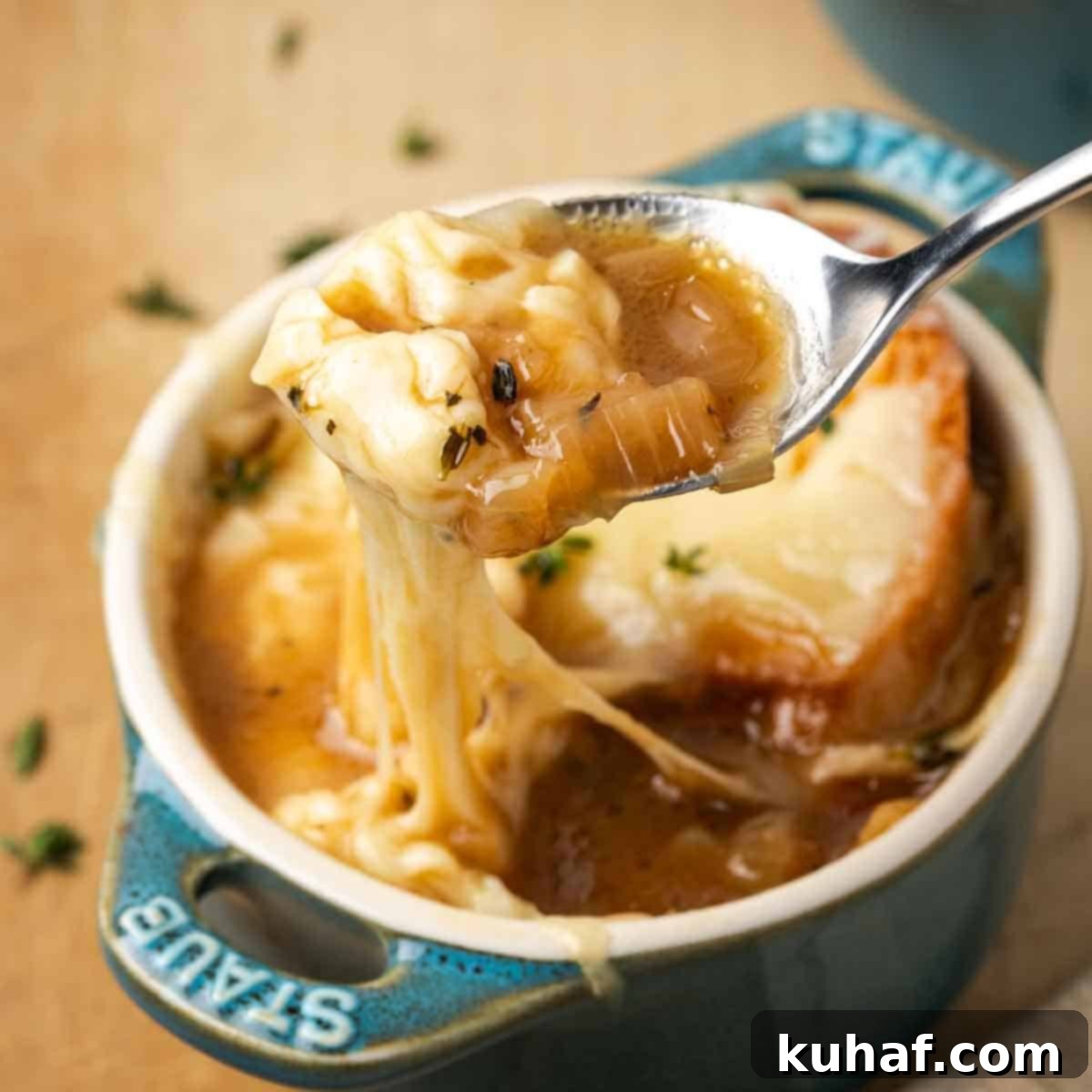 perfect bite of french onion soup on spoon.