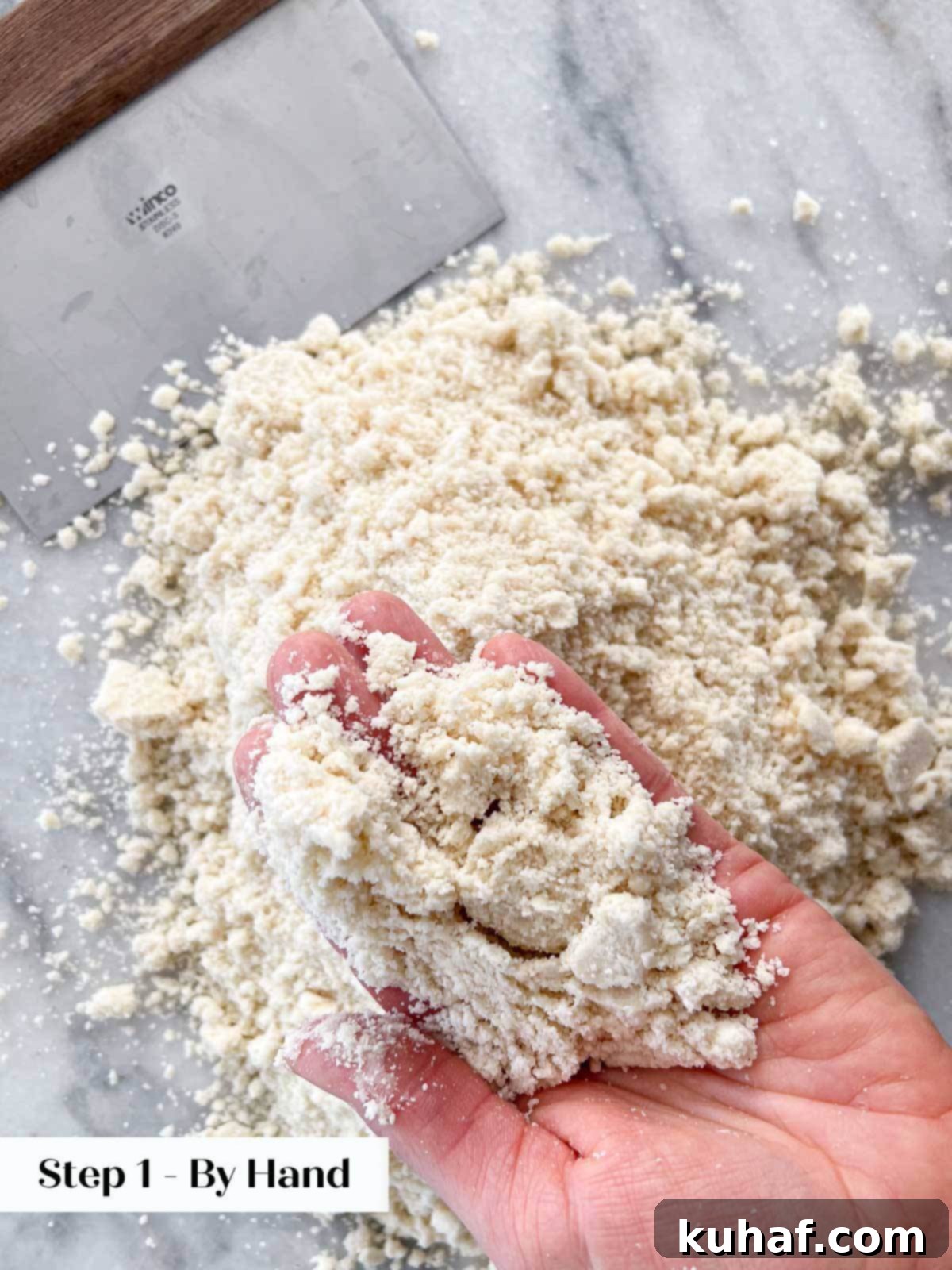 Shortening perfectly cut into flour by hand, shown in a bowl.
