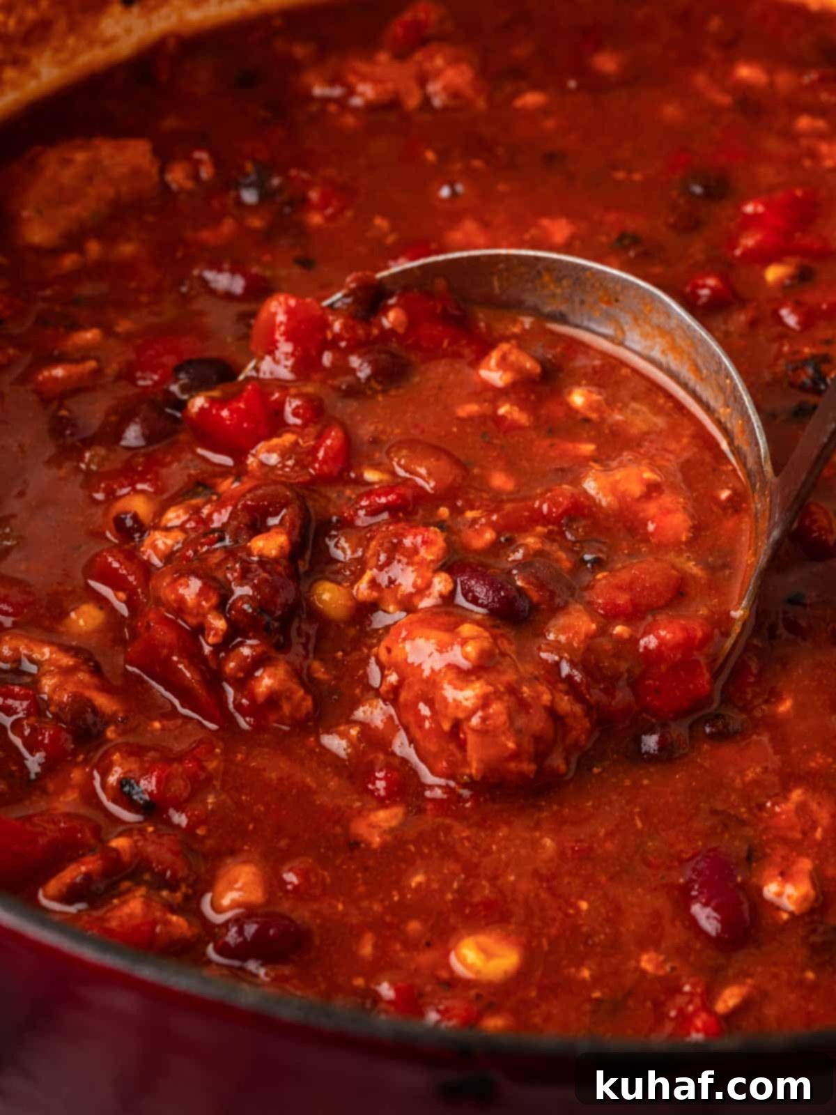 Smoky Chipotle Heat 4 A ladle scooping rich, smoky chipotle chili from a pot, ready for serving.