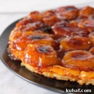 Apple Tarte Tatin, a classic French dessert, presented on a black plate.