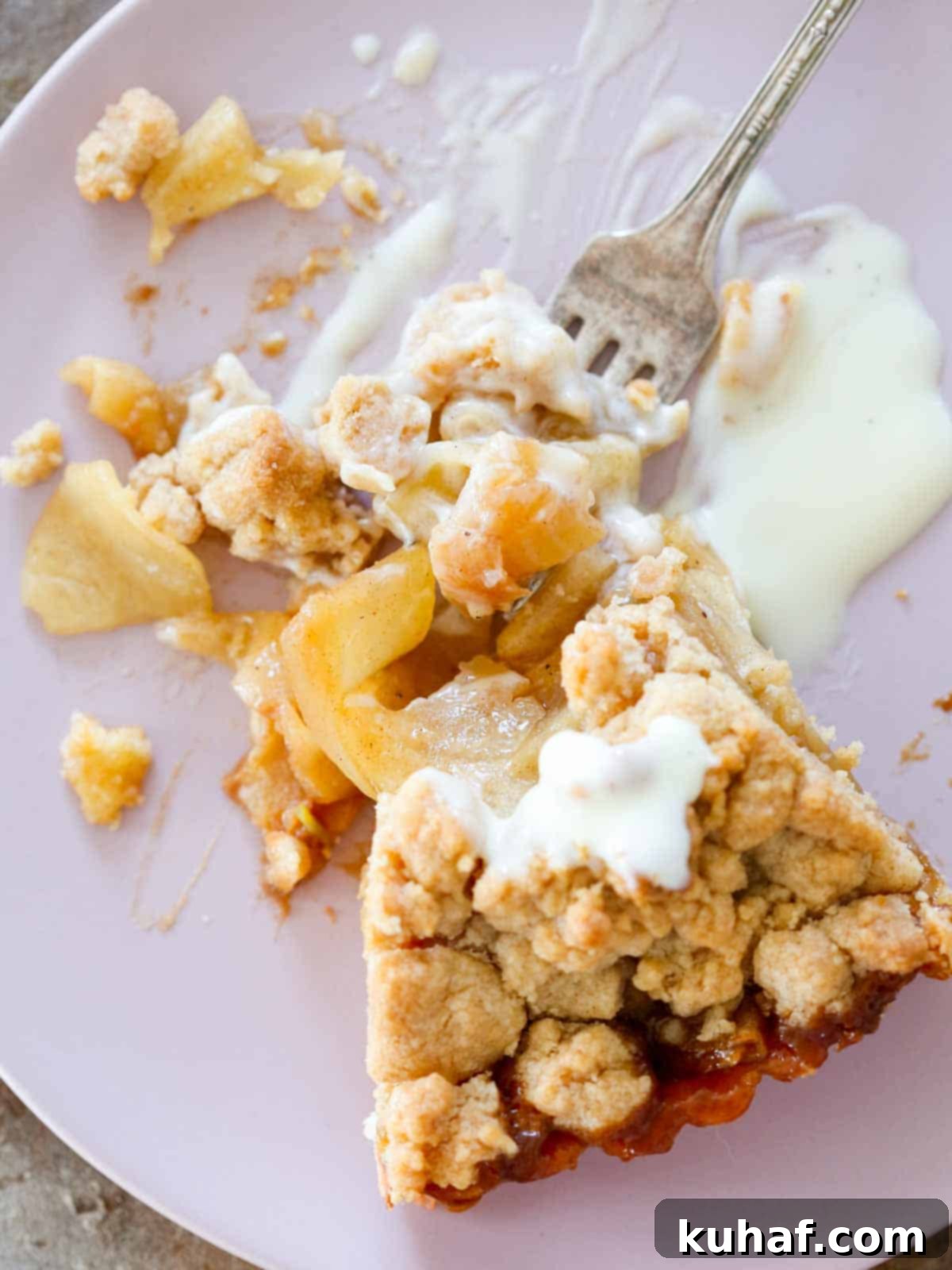 Decadent caramel apple tart with crème anglaise on a plate, highlighting its rich layers.