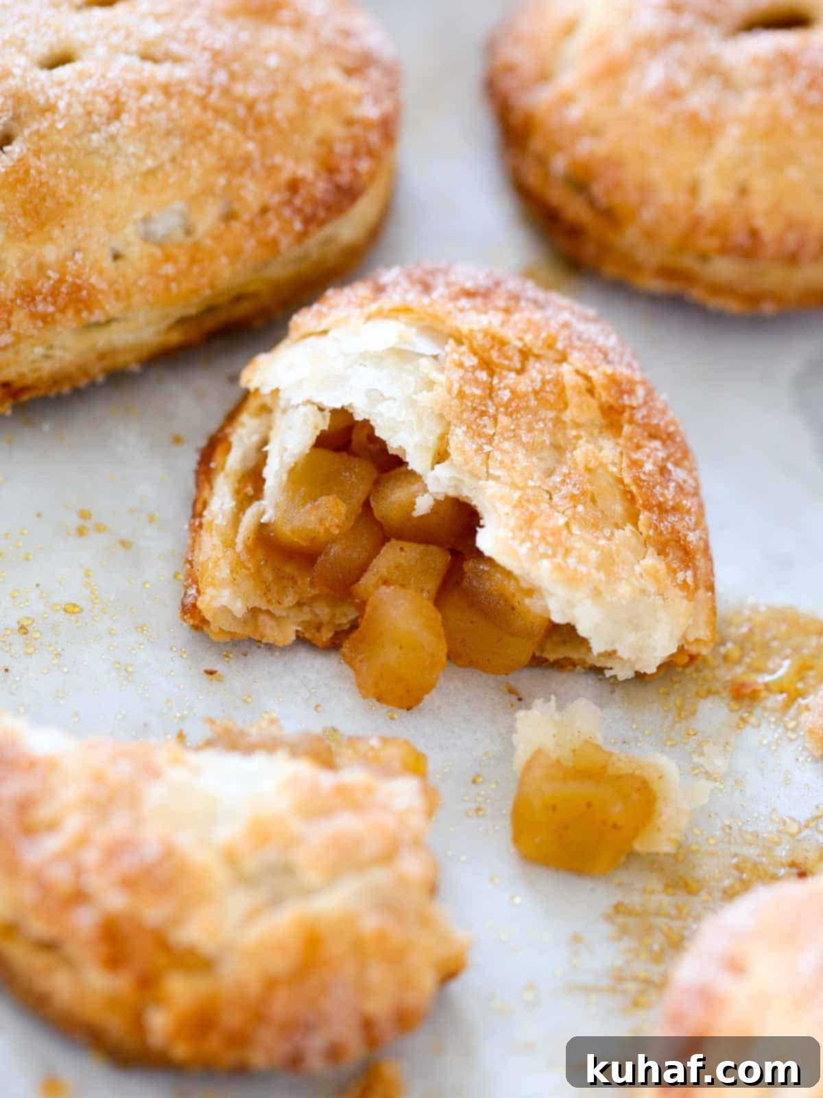 An appetizing apple hand pie, with one half broken open to reveal its luscious apple filling.