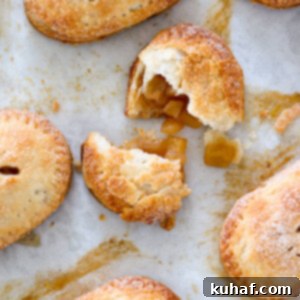 Overhead shot of Apple Hand Pies on a baking sheet, close-up, showing their golden crusts.