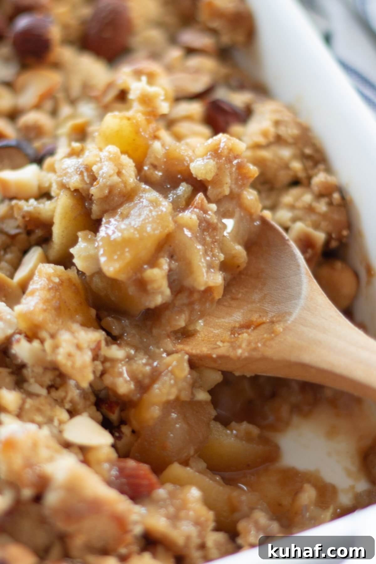 A spoonful of ginger spiced apple crumble, showing its rich filling and crispy topping.