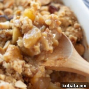 A rustic Ginger Spiced Apple Crumble in a baking dish, with a spoonful removed.