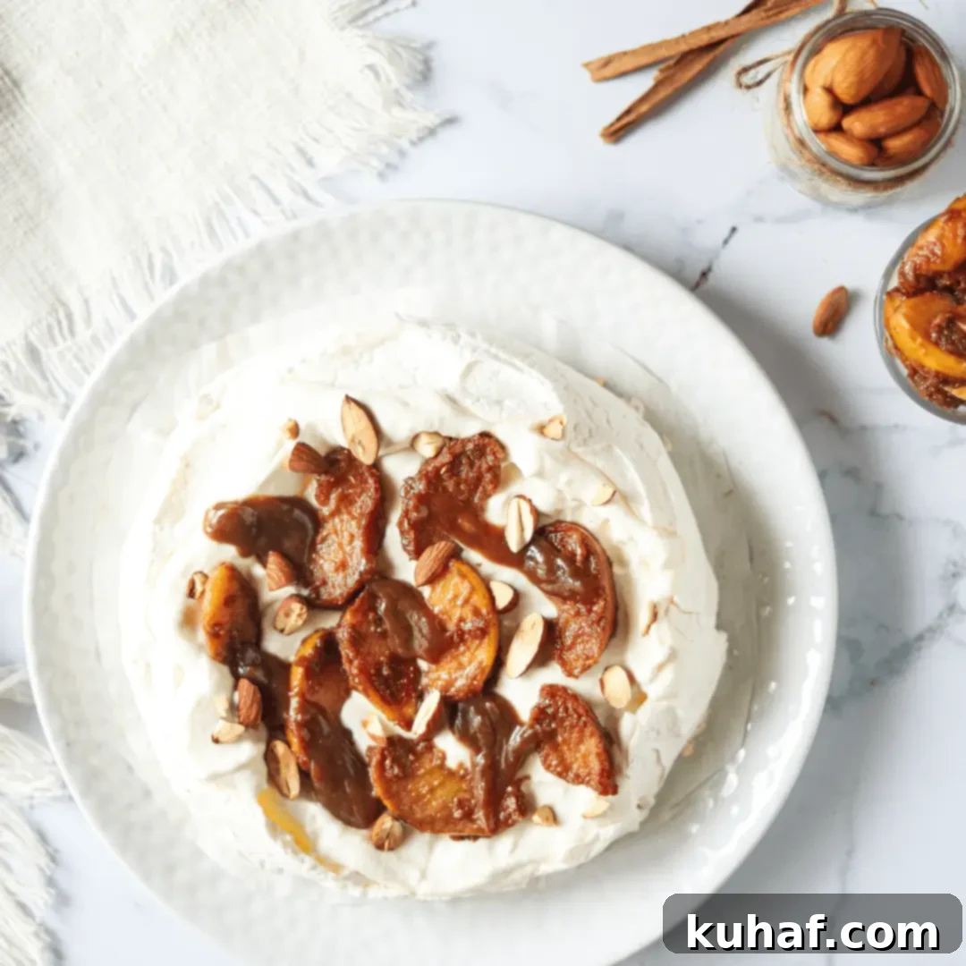 Elegant apple pavlova on a marble surface, adorned with cooked apples and cream.