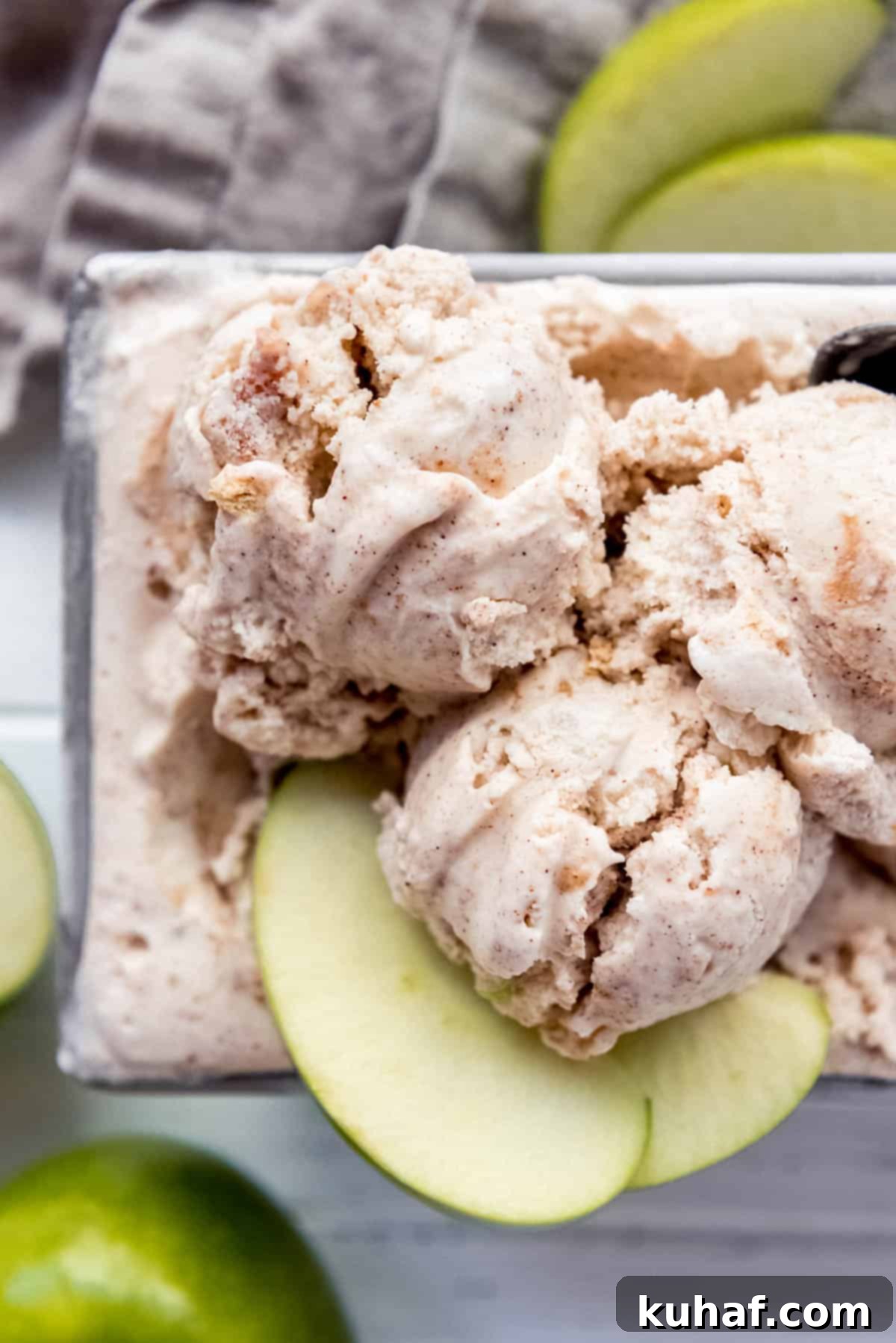 Creamy apple spiced ice cream in a bowl, garnished with fresh apple slices.