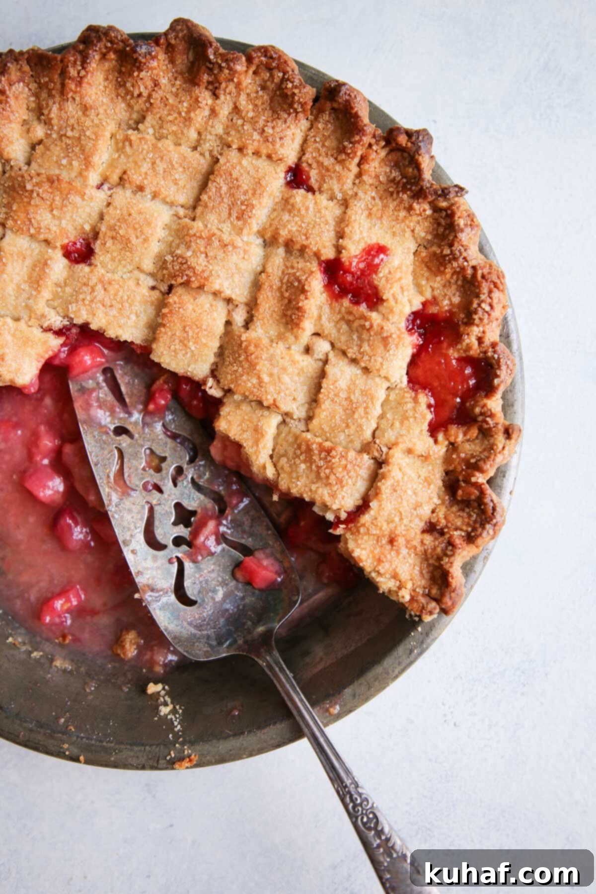 Simple Steps to a Beautiful Lattice Pie Crust 2 sliced and served strawberry rhubarb pie in metal tin.