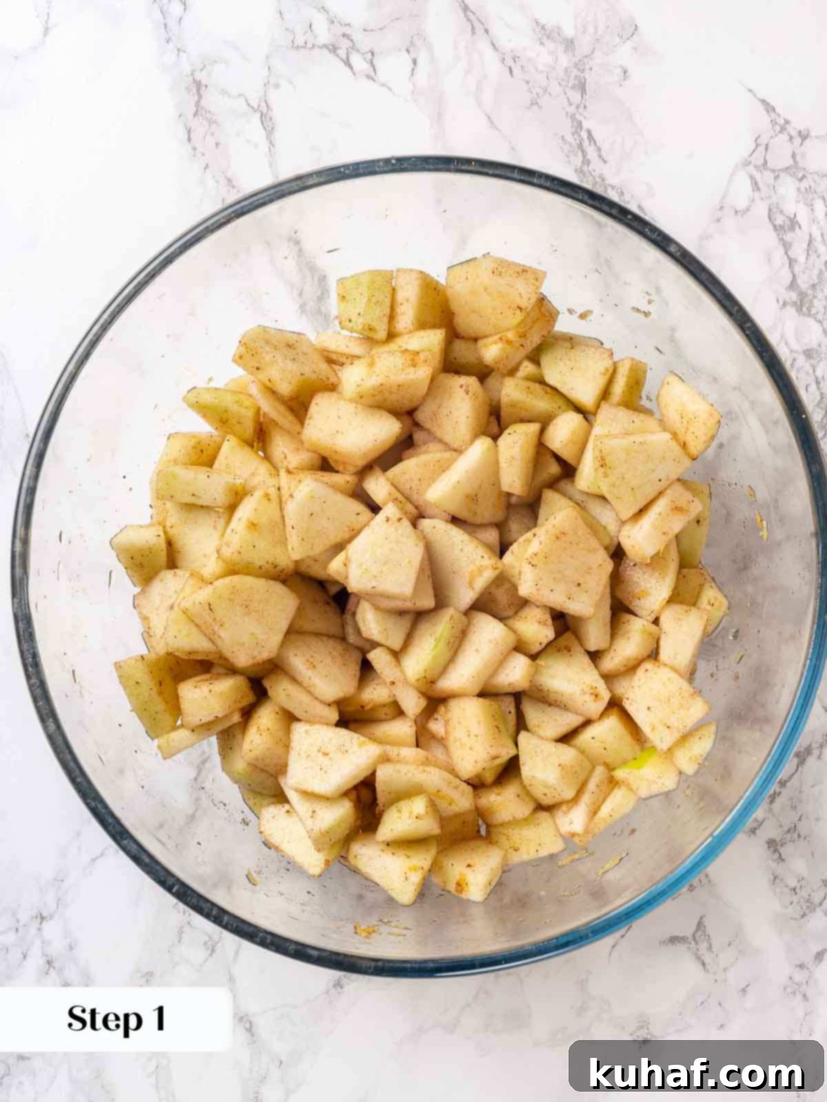 Sliced apples mixed with cinnamon, sugar, and lemon juice in a bowl, ready for maceration.