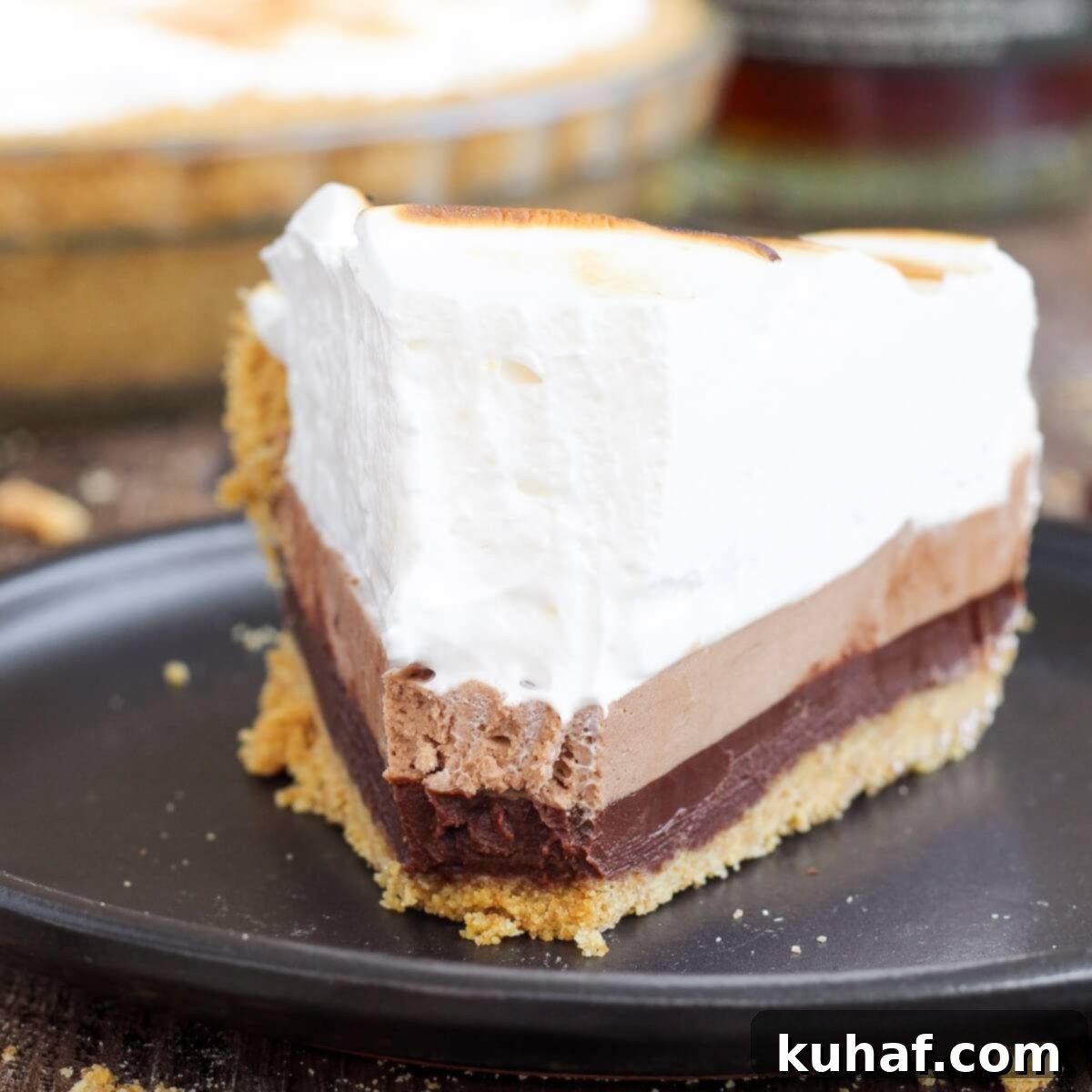 whiskey smores pie on black plate.