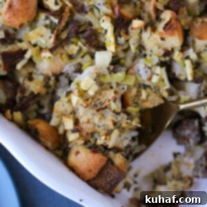 Apple Sage Sausage Stuffing being served with a spoon.