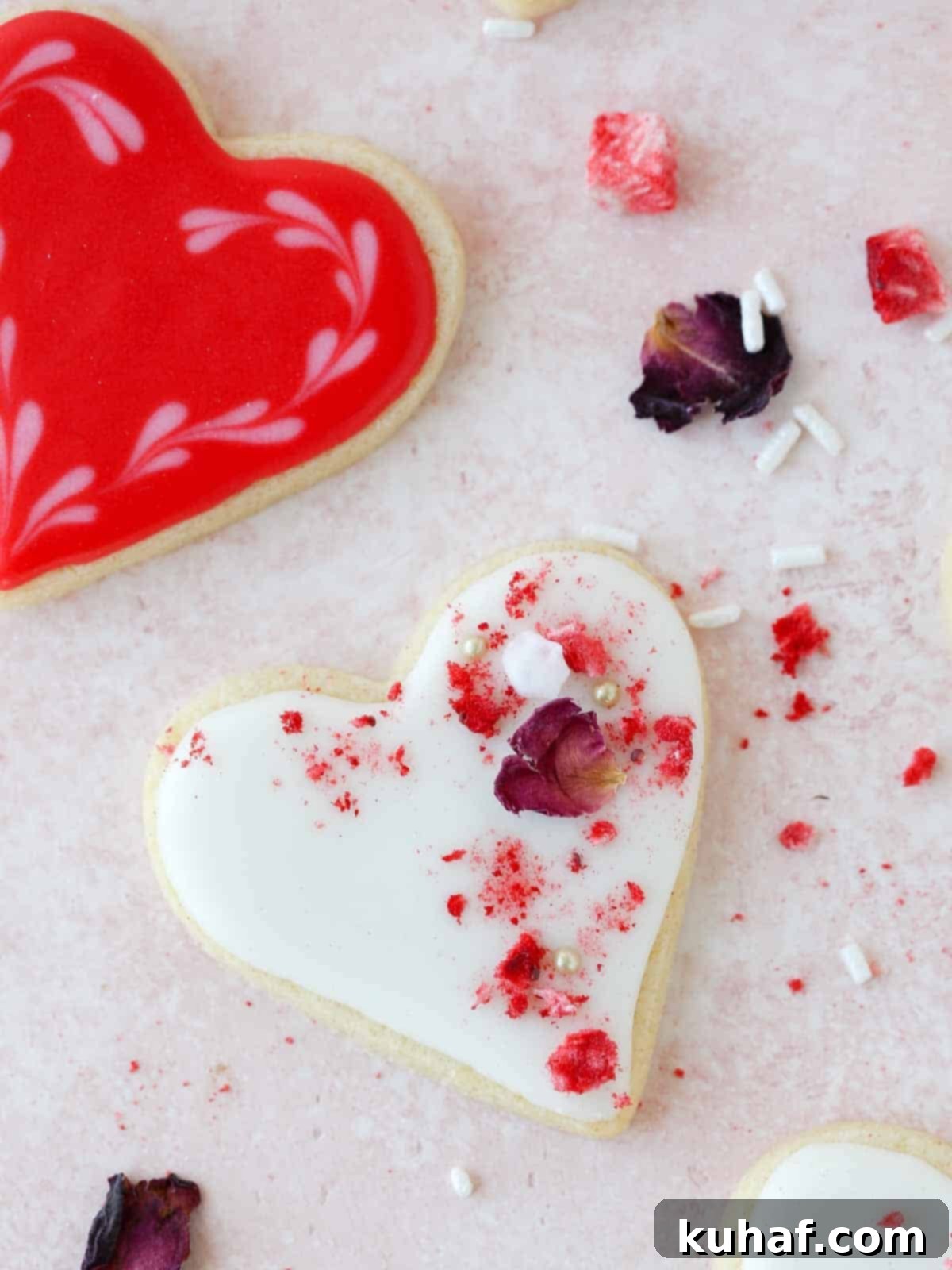 Decorated heart sugar cookies arranged artfully on a festive pink background, perfect for Valentine's Day or Galentine's Day celebrations.