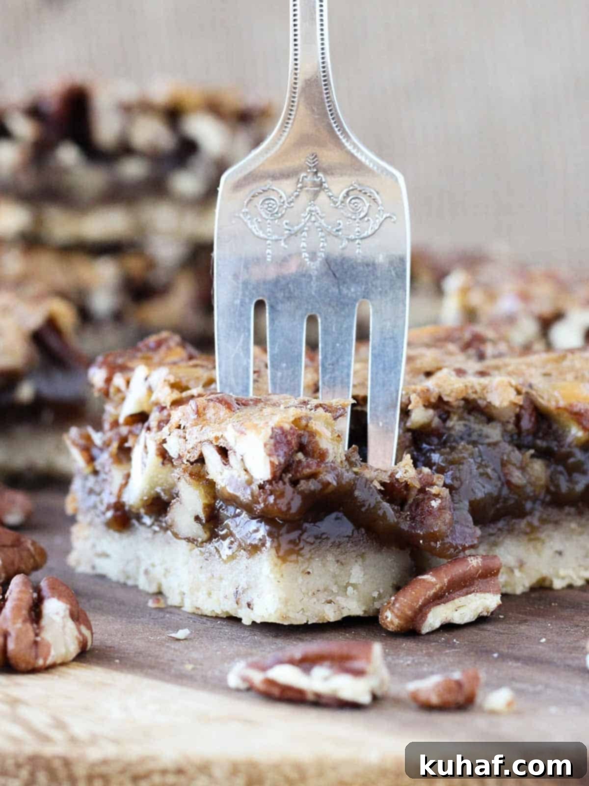 A single pecan pie bar, golden and rich, with a fork poised to take a bite, highlighting the gooey texture and nutty topping.