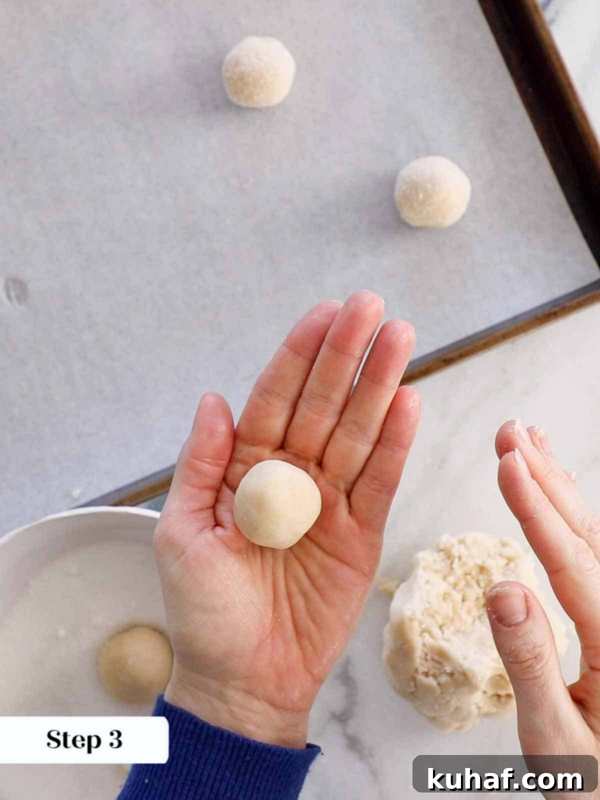Hand rolling cookie dough into a smooth ball.