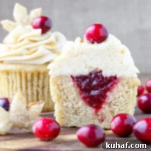 Spiced Apple Cider Cranberry Cupcakes: Moist cake with a spiced cranberry filling and luscious cinnamon cream cheese frosting, garnished with pie crust leaves.