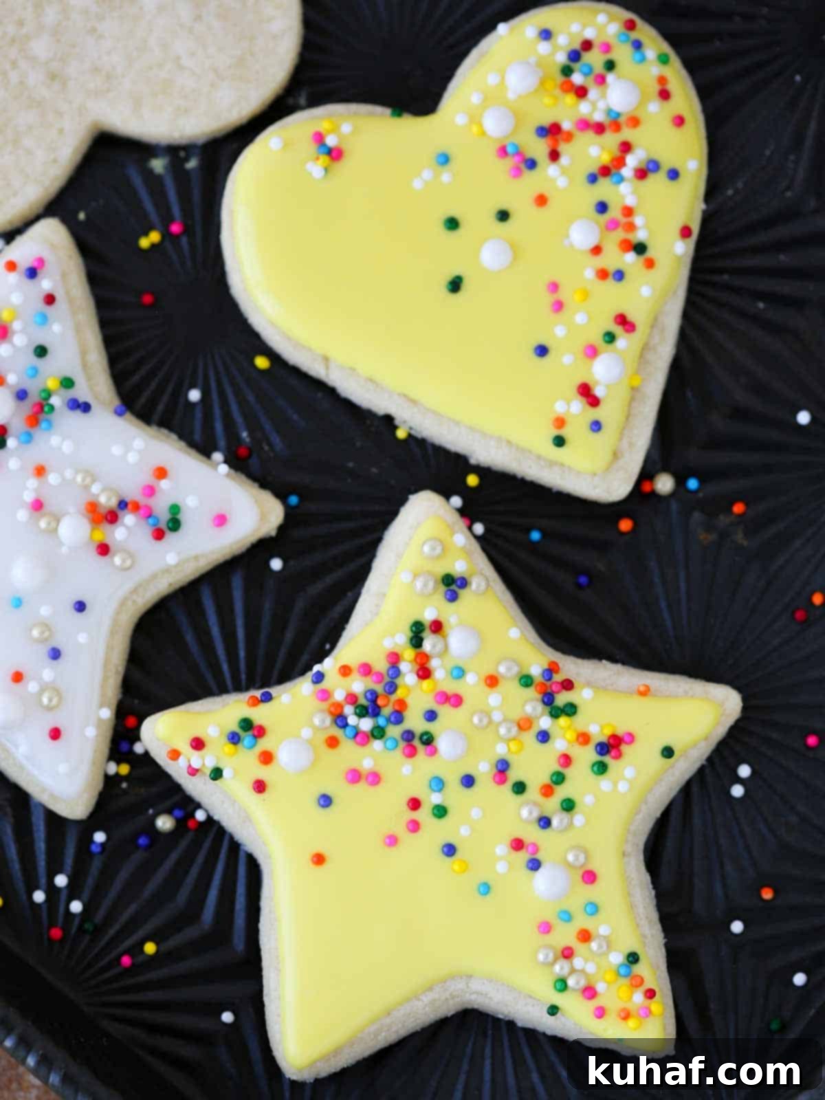 yellow star and heart cookies on black tray.