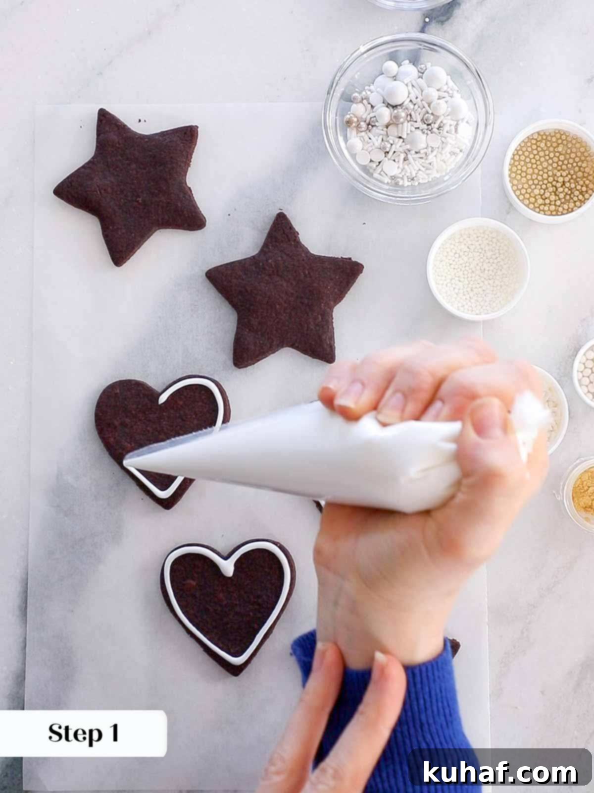 outlining a chocolate sugar cookie with easy cookie icing for decoration.