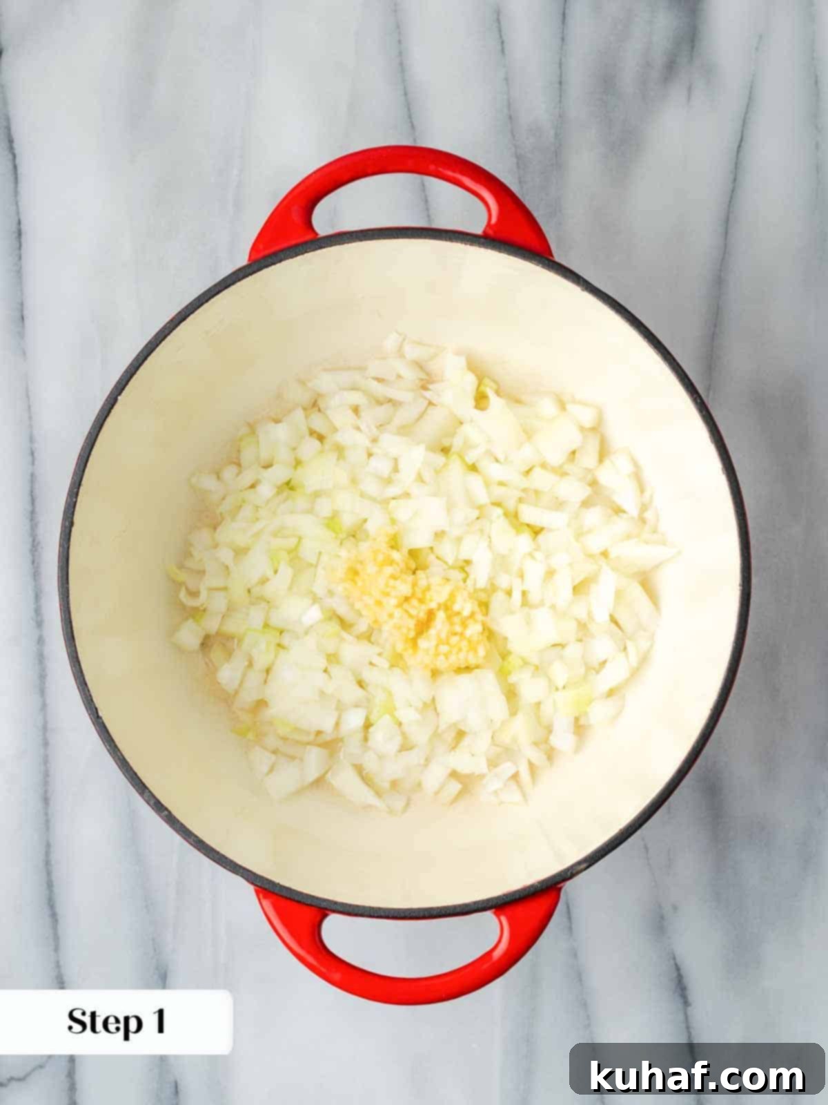 Sautéing onions and garlic in a red Dutch oven.