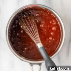 Homemade BBQ sauce boiling, showing its rich texture and color, indicative of deep flavor.