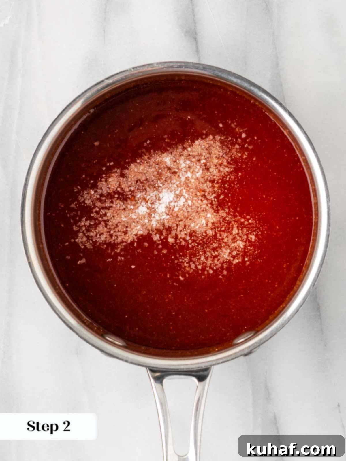 Adding salt to taste during the simmering process of homemade BBQ sauce, balancing the flavors.