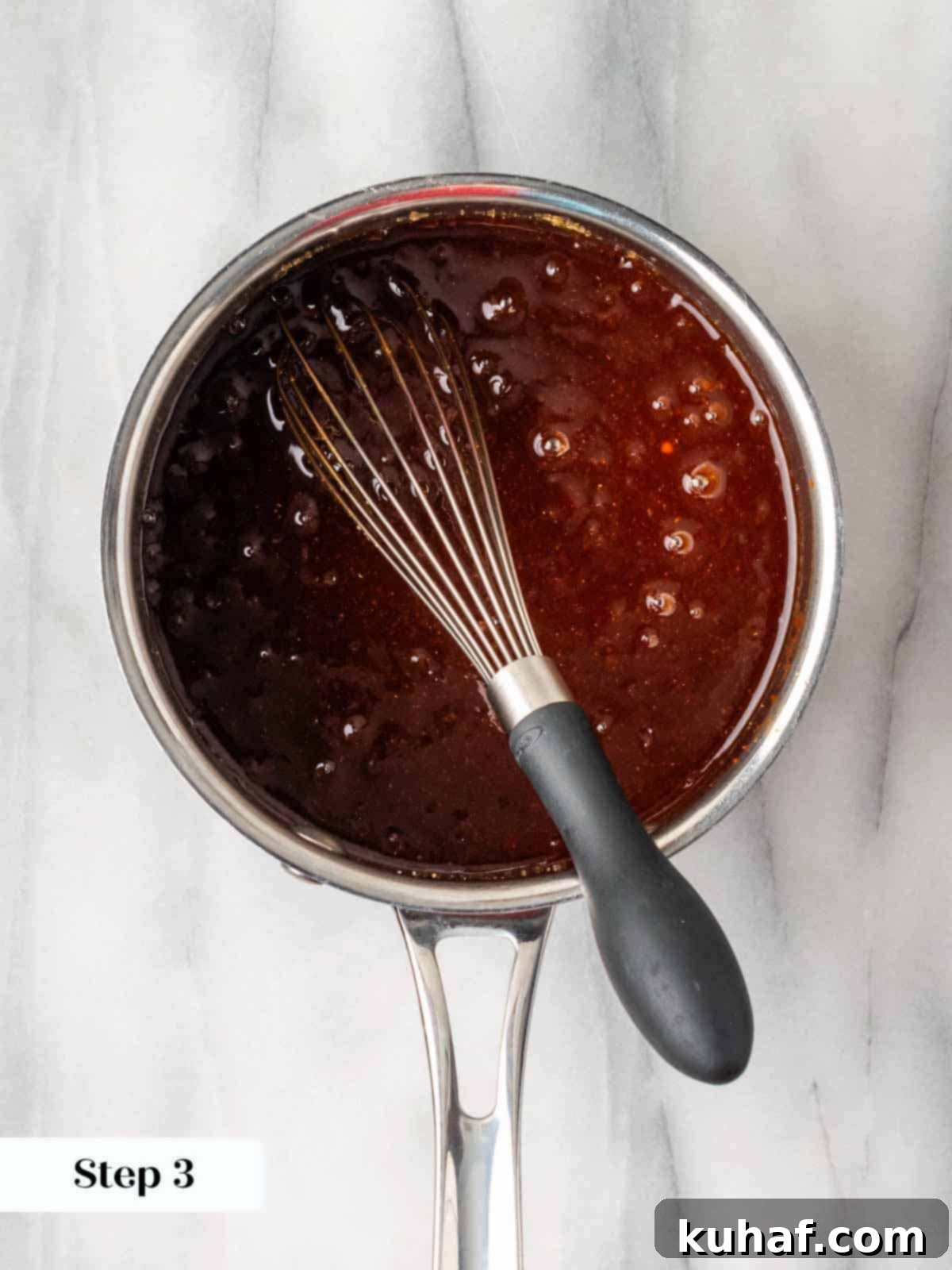 Homemade BBQ sauce boiling gently on the stovetop, visually demonstrating the thickening and flavor development.