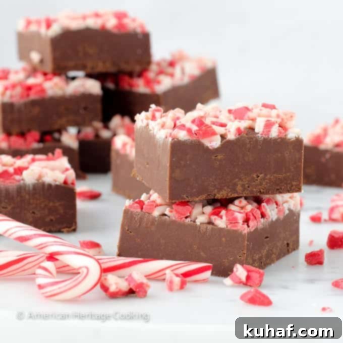A stack of Easy Dark Chocolate Peppermint Fudge squares, showcasing their perfect shape and festive topping, ready to be enjoyed.