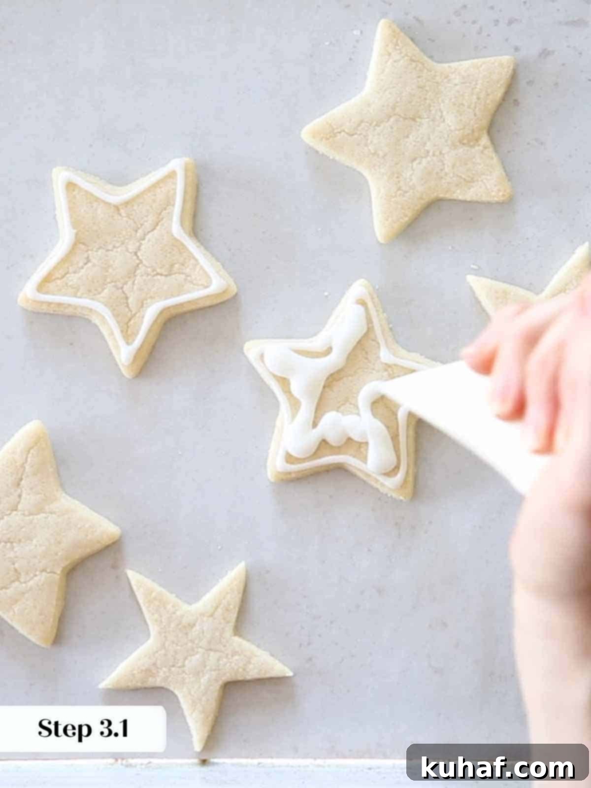 squiggling white royal icing on sugar cookie stars.
