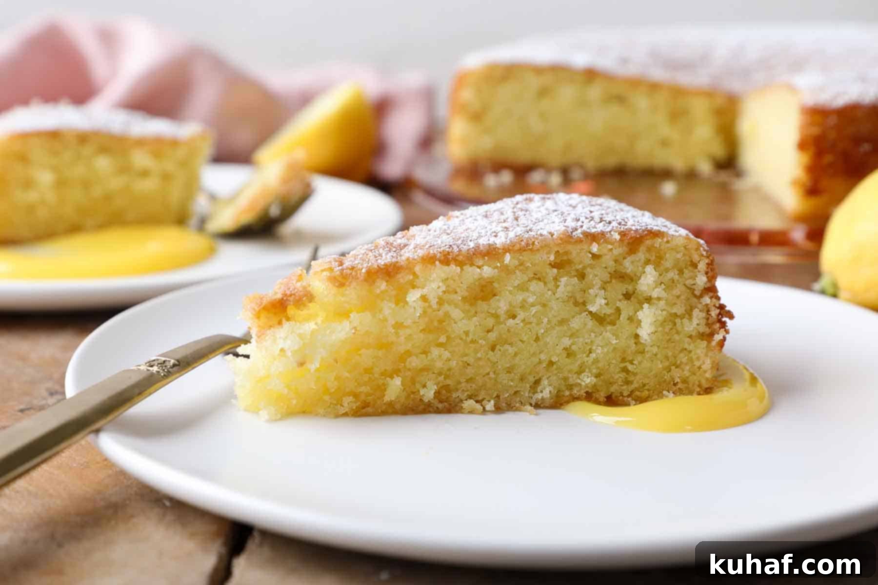 side of a slice of lemon olive oil cake on white plate.