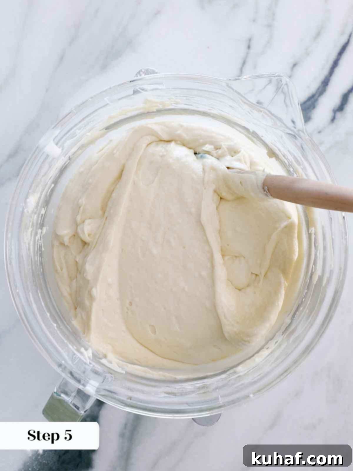 Finishing the mixing of vanilla cake batter by hand with a spatula.