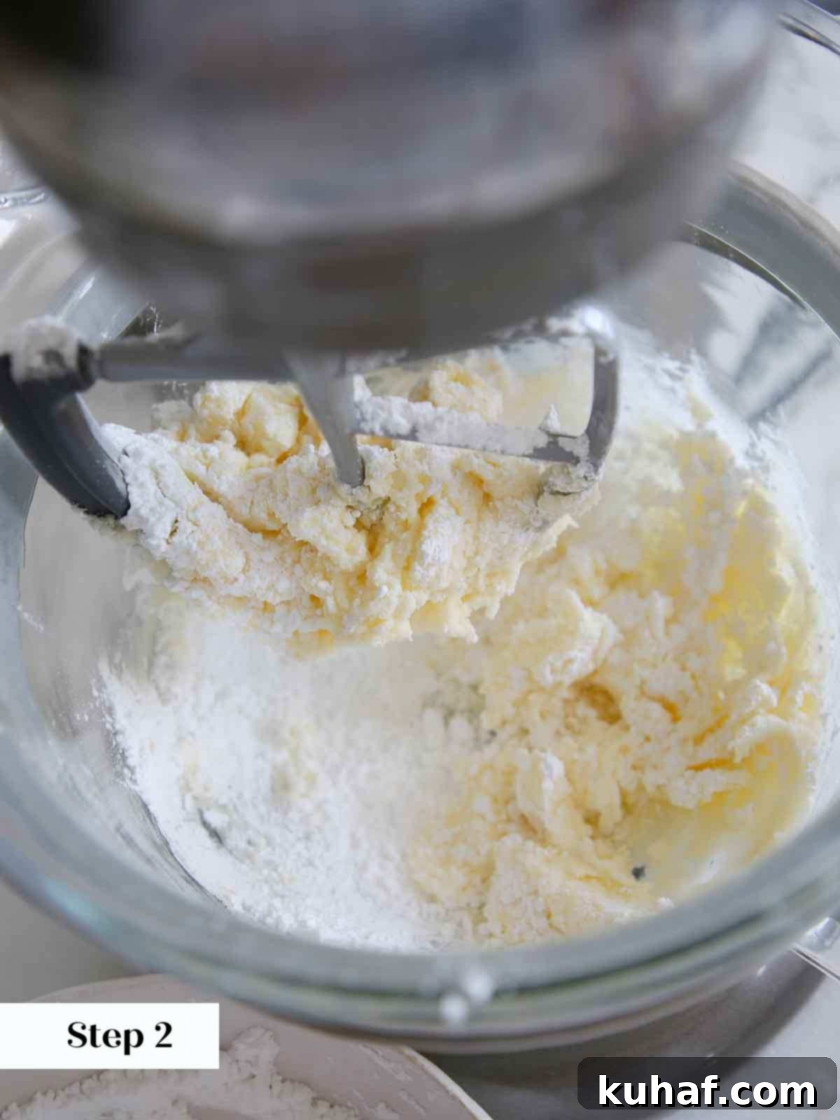 Mixing powdered sugar into softened butter for vanilla buttercream.