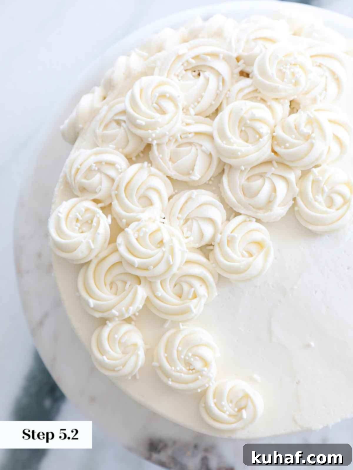 Beautifully piped vanilla American buttercream rosettes adorning a cake.