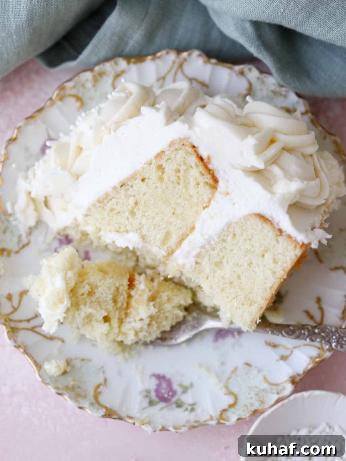 A delectable slice of moist vanilla cake, showcasing its tender crumb and elegant presentation on a vintage purple plate.