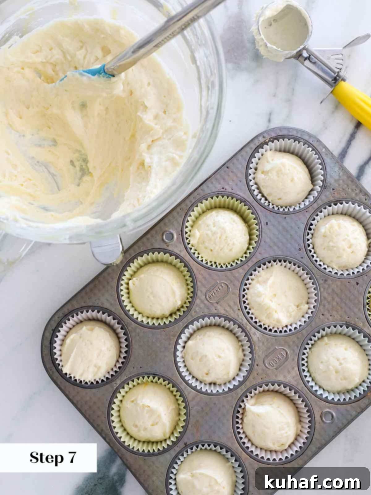 portioning lemon cupcake batter into liners.