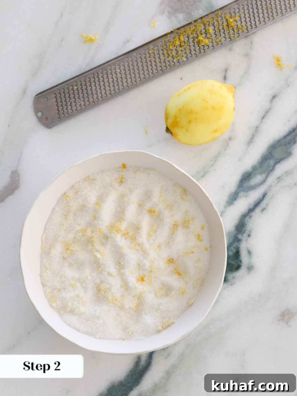lemon zest combined with sugar in white bowl.