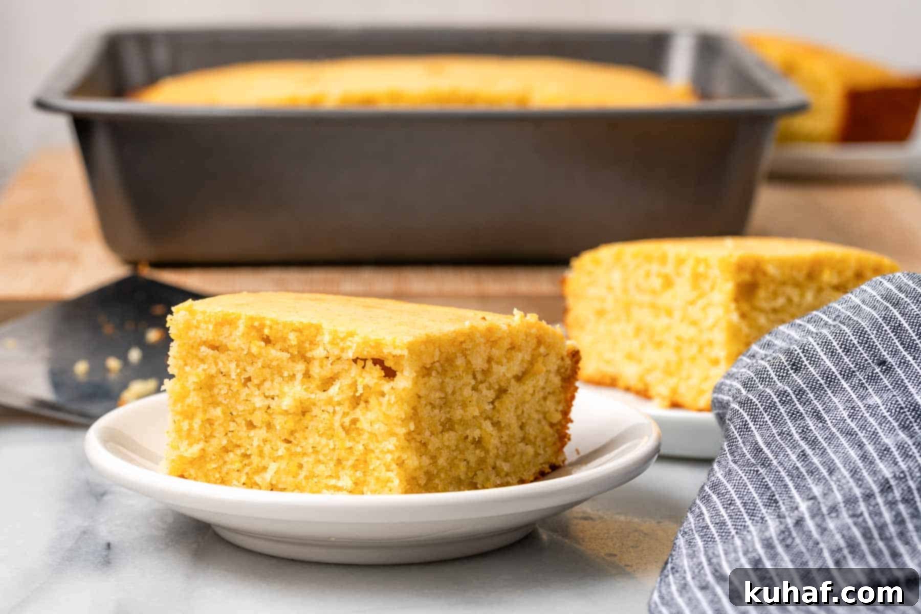 sweet cornbread slices on white plates with baking dish in background.