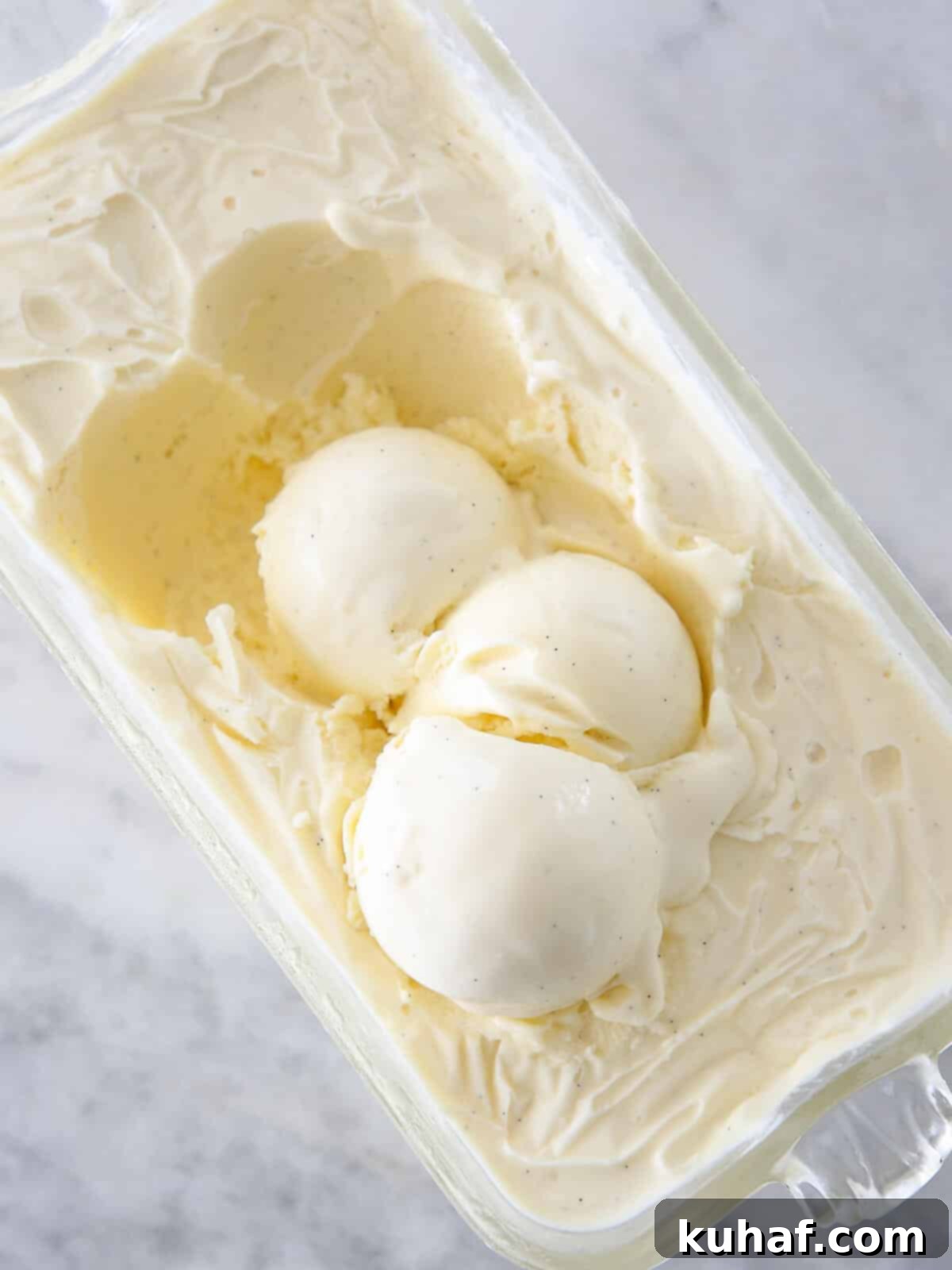 three scoops of vanilla ice cream in container.