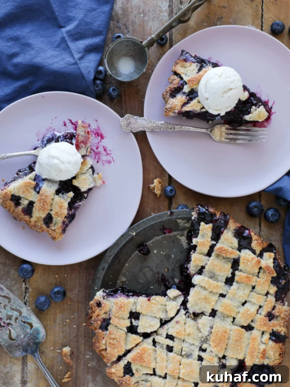 blueberry pie sliced on pink plates wooden background.