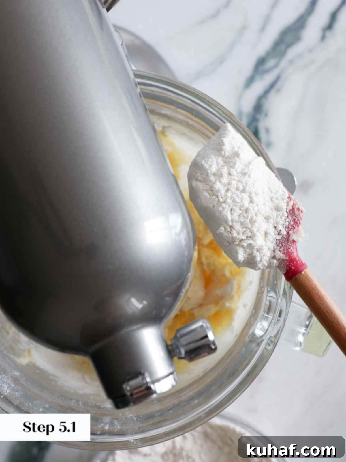Dry ingredients being added to the mixing bowl to make funfetti cookie dough.