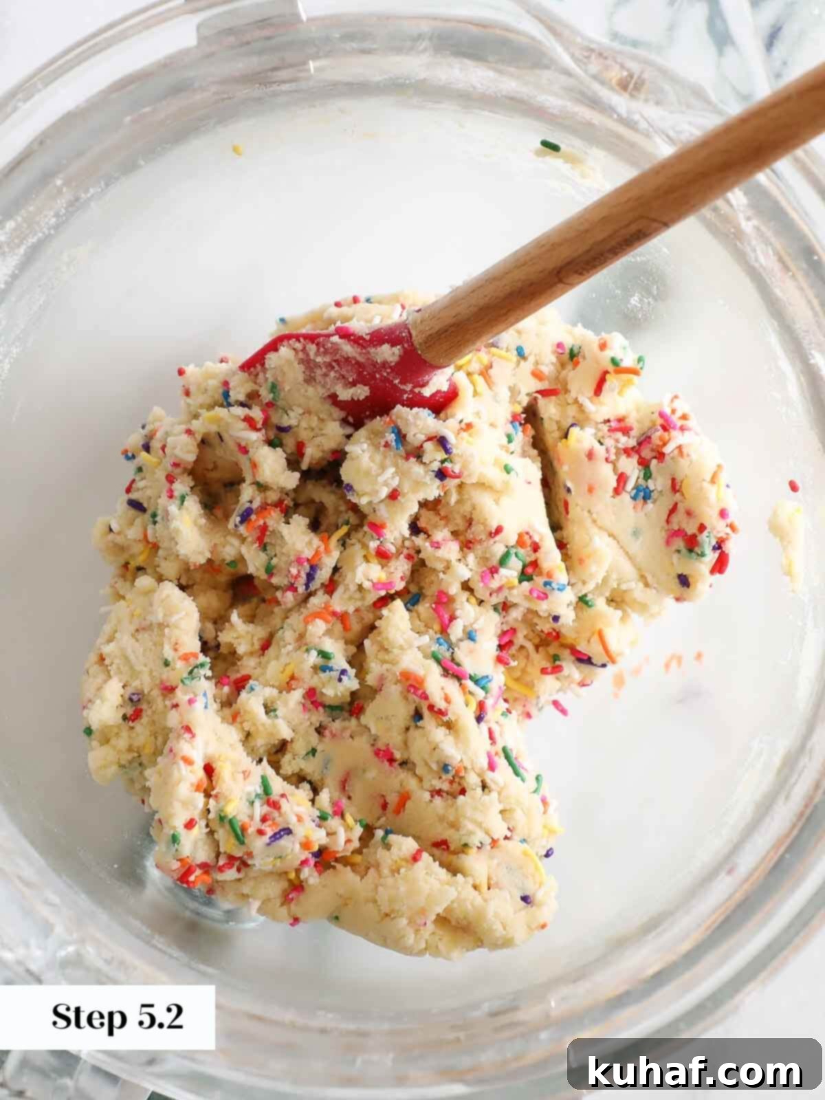 Sprinkles being gently folded into the funfetti cookie dough.