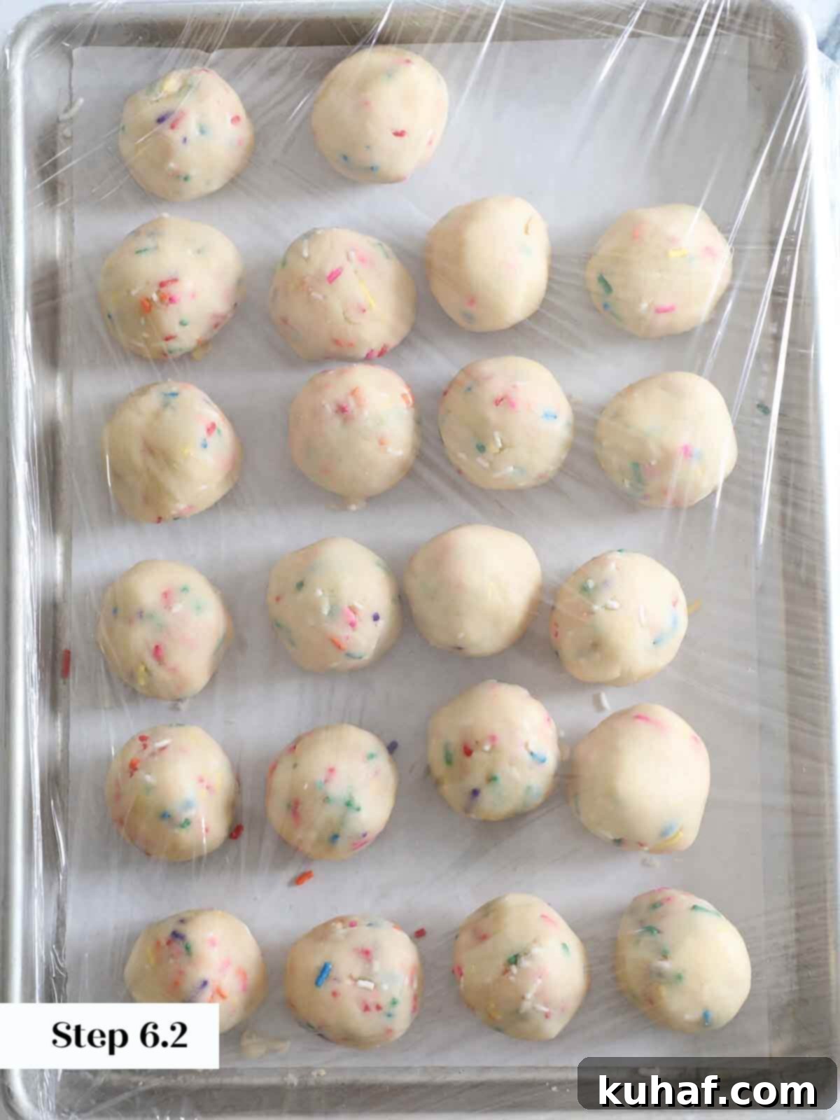 Funfetti cookie dough wrapped in cling wrap, ready to be chilled before baking.